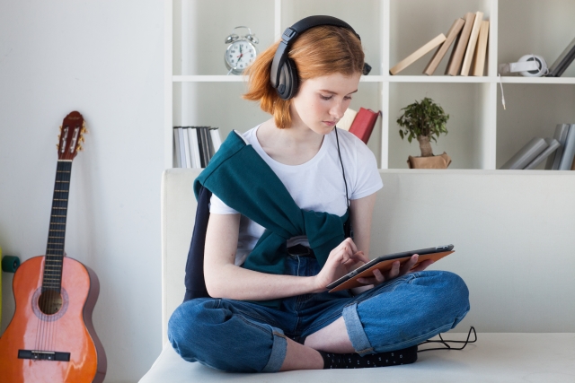 iPadで音楽を聴きながら操作する女性